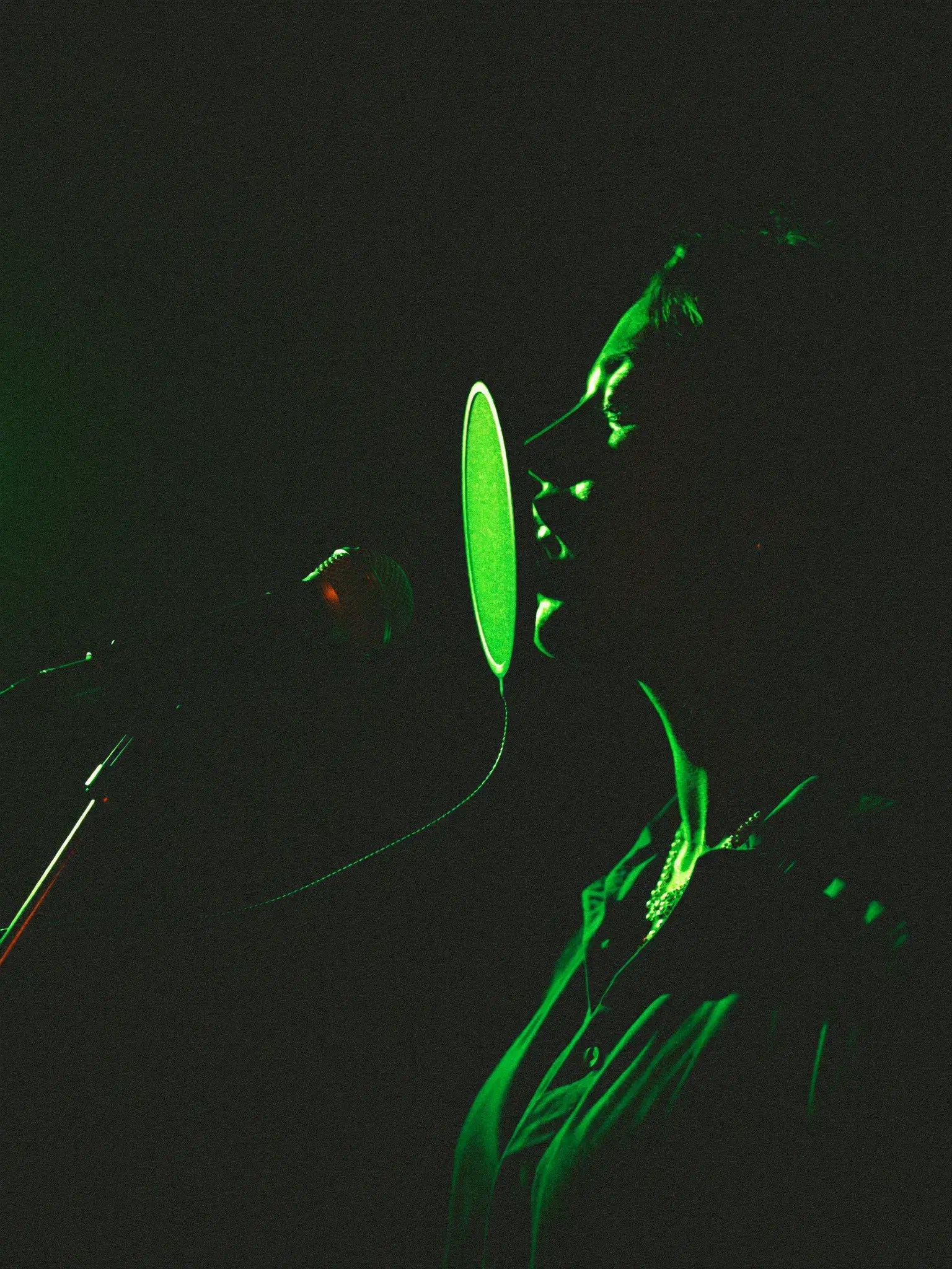 Vocalist tracking in the 1331 Recordz isolation booth under green rim lighting